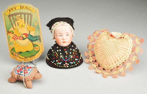 Heubach "Baby Stuart" Pincushion and Sewing Items: Baby Stuart" bisque head with molded white bonnet with painted flower and vine decoration, cut out section on top of bonnet with fabric insertion for the black lace bonnet pincushion, also decorated w
