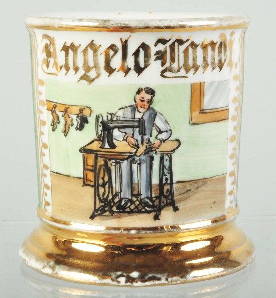 Shoemaker at Sewing Machine Shaving Mug.: Gilt name "Angelo Tandi". Full green wrap. Shows a shoemaker making a pair of shoes. Germany mark on bottom. Some minor gold loss. Size: 3 - 3/4" T.