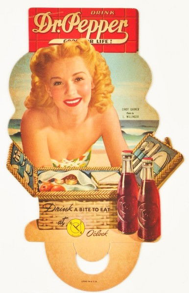Cardboard Dr. Pepper Bottle Topper.: 1940s. Features Cindy Garner. Minor surface bend in upper left corner; otherwise, miniscule marks or slight darkening. Size: 9 - 3/4" T.
