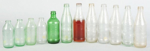 Lot of 12: Glass No-Return Soda Bottles.: 1950s to 1970s. Includes ten Dr. Pepper, one 7up, and one Coca-Cola in different styles. Most are very clean with only light wear, one is still partially filled and capped. Size: Largest: 8" T.