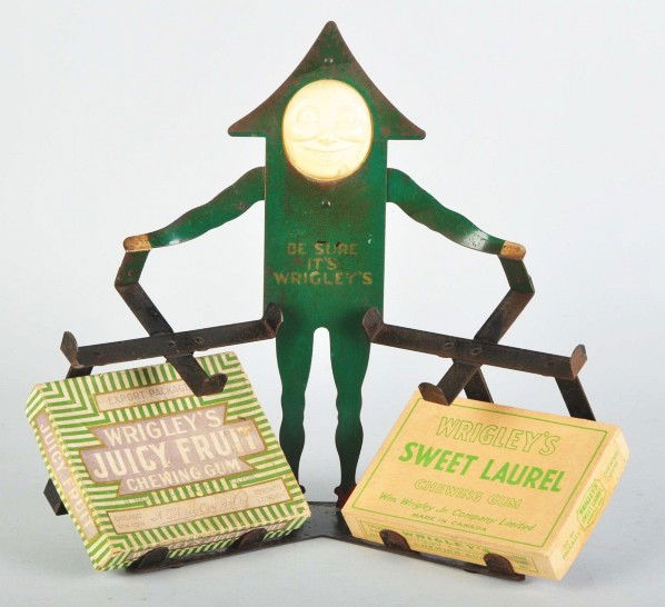 Wrigley's Gum Countertop Display Sign.: 1930s to 1940s. Tin and celluloid construction. Includes two older boxes for display. General overall medium to heavier wear, some minor surface rust, and fading to the face. Size: 13 - 1/2" T.