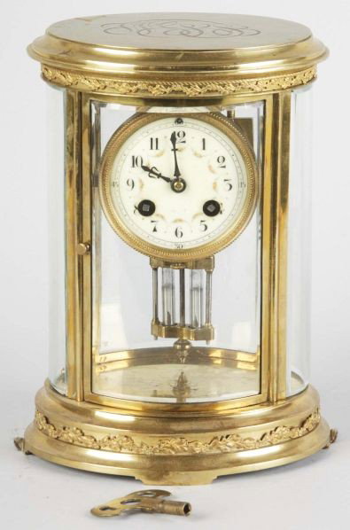 Crystal Regulator Clock With Mercury Pendulum.: French. Circa 1870. Unusual oval brass case with engraved top. Porcelain dial. Serial 346246. Eight day time and strike. Size: 10" x 7" x 6".