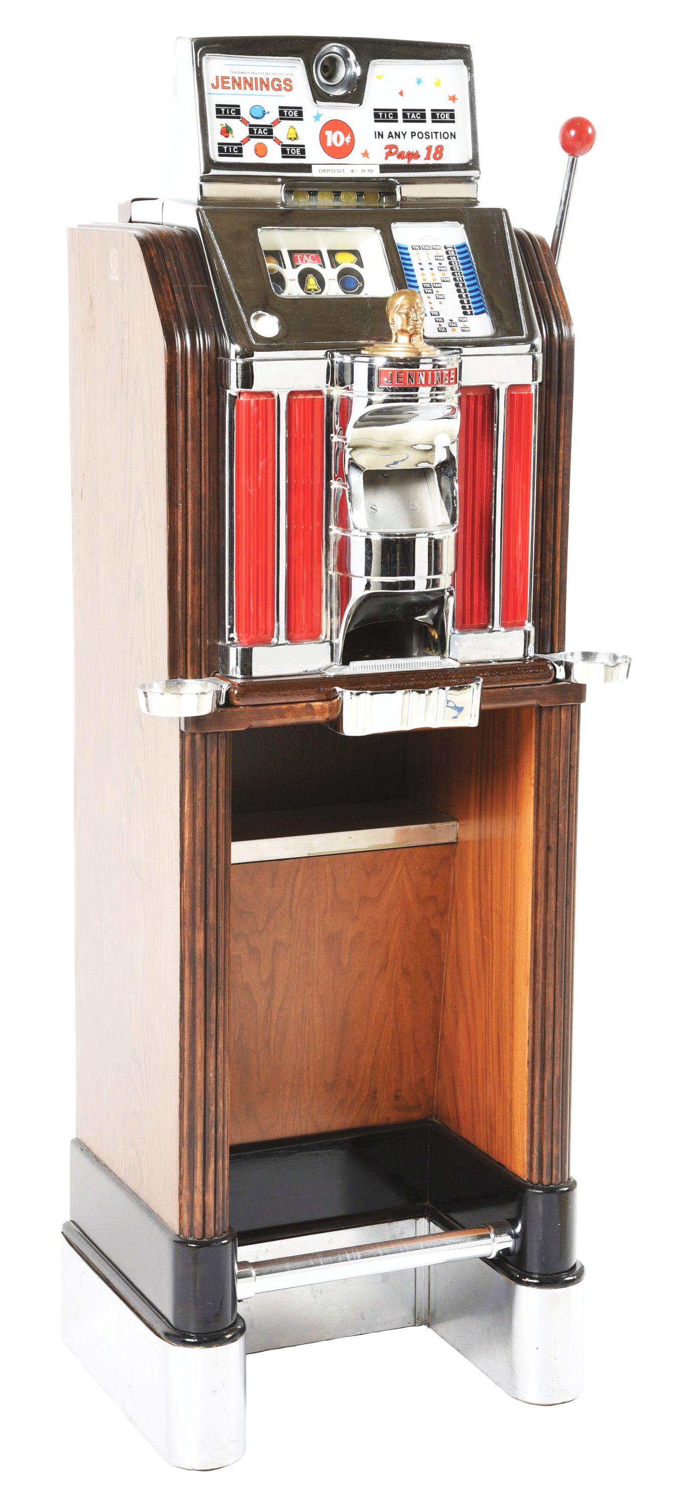 10¢ JENNINGS TIC-TAC-TOE LIGHT-UP CONSOLE SLOT MACHINE.: 1930, USA: Top glass panel reads "Jennings" with Tic-Tac-Toe motif. CONSIDERATIONS: This machine has replacement reel strips, replacement cashbox, original back door with replacement lock. It has been