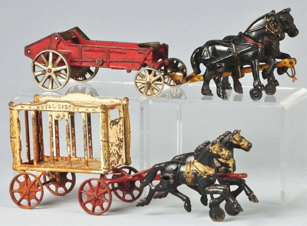 Lot of 2: Cast Iron Horse-Drawn Vehicle Toys.: Includes one medium-sized Hubley Royal Circus cage wagon missing driver and animal and one Arcade McCormick-Deering farm toy with nickel wheels, "Arcade" sticker on side, and embossed "McCormick-Deeri