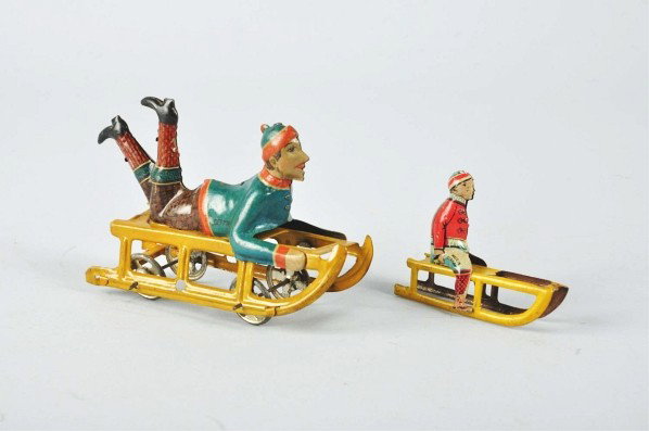 Lot of 2: Tin Litho Sled Toys.: German. Includes one nickel-size toy with wheels and one penny toy size. Both are marked "Made in Germany". Very little wear overall. Size: Largest: 4 - 1/4" L.