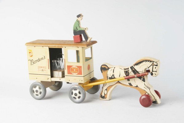 Rich Toys Borden's Horse-Drawn Milk Wagon.: Wood and tin. Includes four original glass bottles and original wooden driver. Cart marked "Borden's". Size: 19" L.