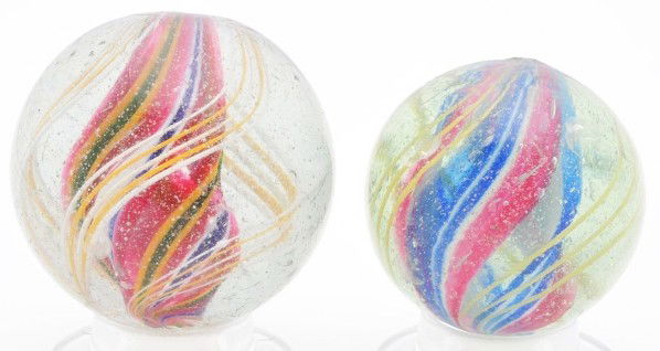 Lot of 2: Large Divided Core Swirl Marbles.: The larger marble has a core of red, white, and cobalt bands, one yellow and green band, and outer band groups of yellow and white latticino. The smaller marble has a core of red, white, and blue with
