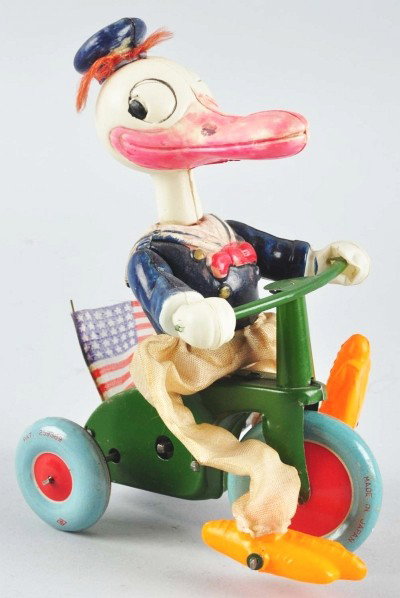 Celluloid Disney Donald Duck Tricycle Wind-Up Toy: Japanese. Circa 1930s. Working. Larger size variation. Distributed by Paradise Novelty. Celluloid figure on tin tricycle. Original cloth pants. Usually has an English flag on back but this toy comes w