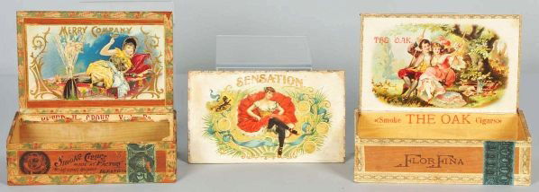 Lot of 3: American Slice of Life Cigar Boxes.: Description 1890s. All are rare. Includes The Oak with man and woman on swing in Victorian clothing, Sensation (lid only) with beautiful woman pictures, and Merry Company depicting a Victorian lady in