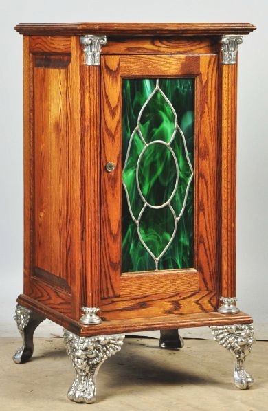 Oak Slot Machine Stand.: Description Cast iron feet and stained glass front. Includes lock and key. Condition (Excellent). Size 34" T.