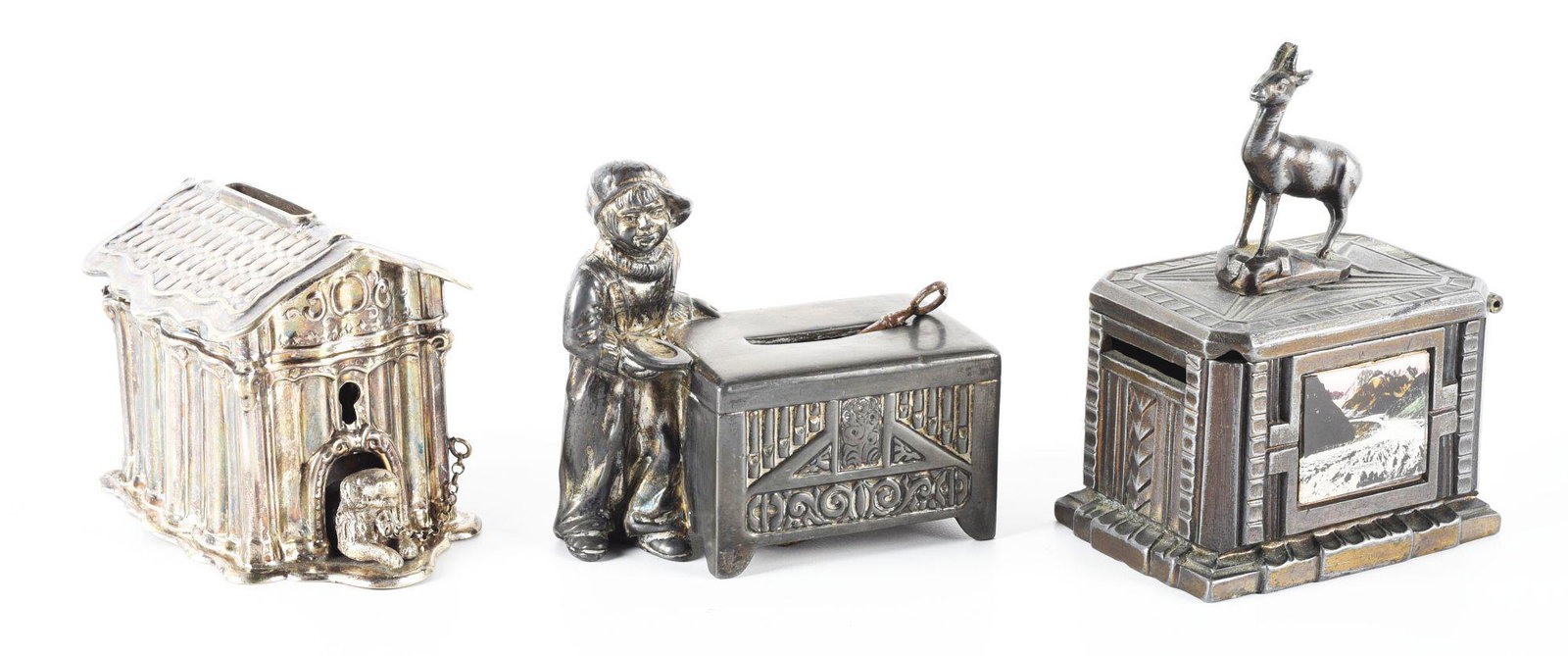 LOT OF 3: VARIOUS TIN & WHITE METAL STILL BANKS.: One shows a child wearing a hat backwards and holding a dish, looking very much like the child actor Jackie Coogan. The second is a French bank with a horned antelope on top, marked "Chmonix" on picto