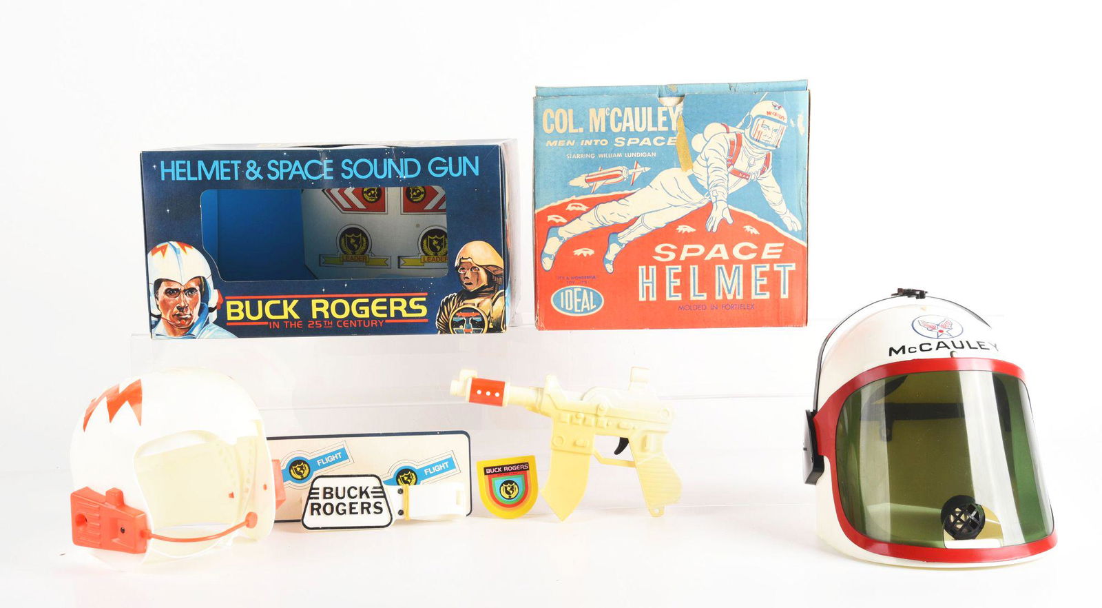 LOT OF 2: VINTAGE PLASTIC SPACE HELMETS.: One is a Buck Rogers in the 25th Century, which is a helmet, belt and sound gun set. The second is an Ideal Col. McCauley Space Helmet with instructions. Some wear to boxes. Condition: (Very Good - Ex