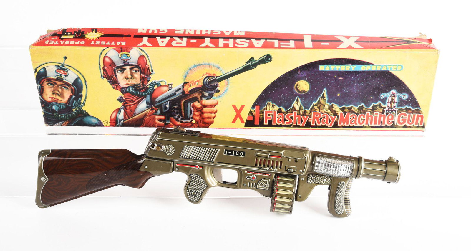 JAPANESE BATTERY OPERATED X-I FLASHY RAY MACHINE GUN.: In original box marked x-a and t.n for nomora. Toy is clean and box has some creasing. Condition: (Very Good - Excellent). Dimensions: 22 - 1/4" x 5 - 1/4" x 2 - 3/4".