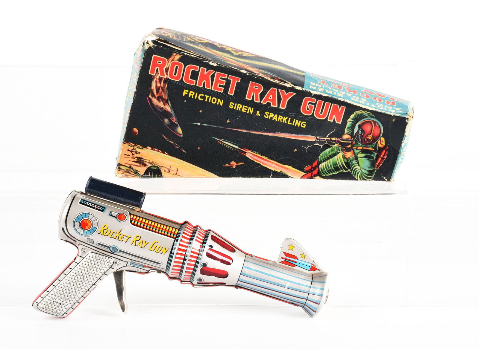 JAPANESE TIN LITHO FRICTION ROCKET RAY GUN IN ORIGINAL BOX.: Box marked Diya. Needs flint to spark. Some creasing on box. Condition: (Very Good - Excellent). Dimensions: 10" x 4 - 3/4" x 2".