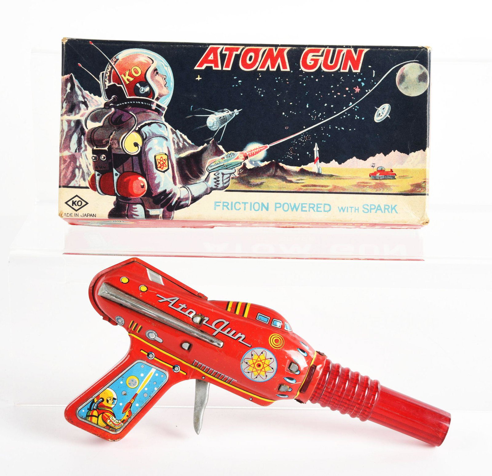 JAPANESE TIN LITHO FRICTION ATOM RAY GUN.: In original box, marked "KO Japan". Nice lithography, with space scene on gun grips. Plastic barrel, with rest tin litho. Nice graphics on box. Condition: (Very Good - Excellent). Dimensions: 9 - 1/4"