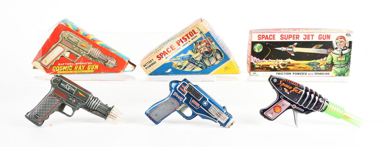 LOT OF 3: JAPANESE TIN LITHO & PLASTIC BATTERY OPERATED & FRICTION SPACE GUNS IN ORIGINAL BOXES.: Cosmic ray gun, Nomara space pistol, and KO space super jet gun. Some creasing and tearing on boxes. Condition: (Very Good). Dimensions: Largest Box: 9 - 1/2" x 4 - 1/2" x 1 - 3/4".