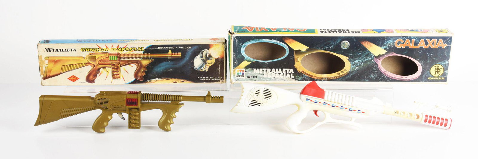 LOT OF 2: PLASTIC SPANISH SPACE RIFLES IN ORGINAL BOXES.: Galaxia click gun and the other is a gohner friction gun. Some creasing and wear on boxes. Condition: (Very Good). Dimensions: Largest Box: 24 - 1/4" x 6" x 2 - 1/4".