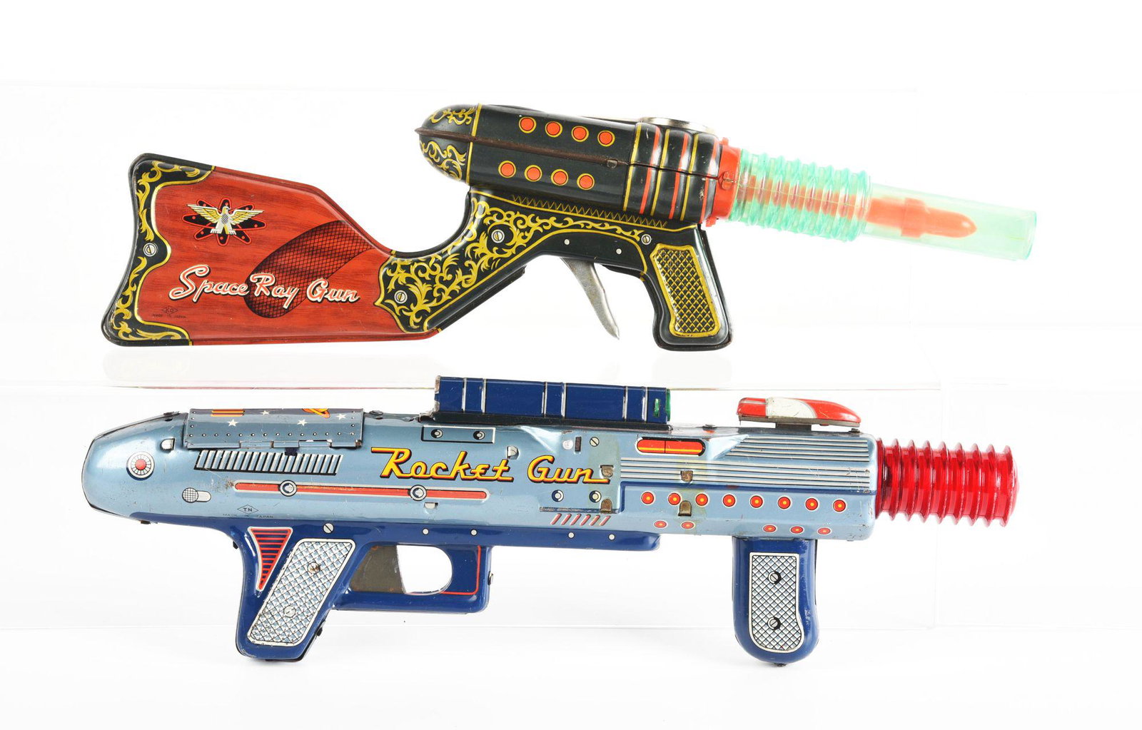 LOT OF 2: JAPANESE TIN LITHO FRICTION & BATTERY OPERATED SPACE RIFILES.: One marked ko japan space ray gun. Other one marked t.n Rocket Gun and has moveable front sight. rocket gun has pieces broken off and pieces missing. Condition: (Very Good). Dimensions: Largest: 14 - 