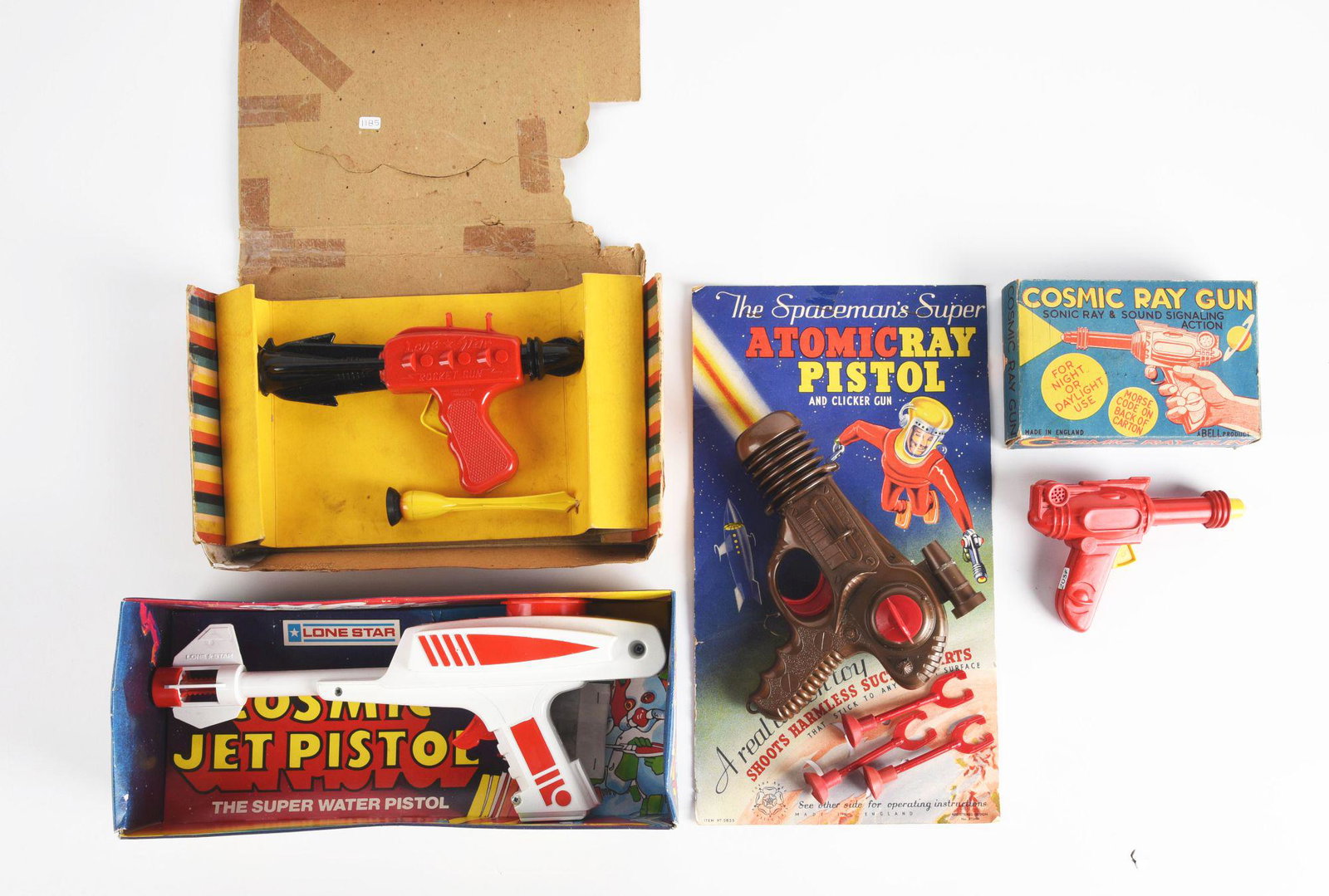 LOT OF 4: MADE IN ENGLAND PLASTIC RAY GUNS.: In original boxes and on original cards several made from Lonestar. Atomic ray pistol, cosmic ray gun, and others. Some creasing on boxes. Condition: (Very Good). Dimensions: Largest Box: 12 - 1/2" x 