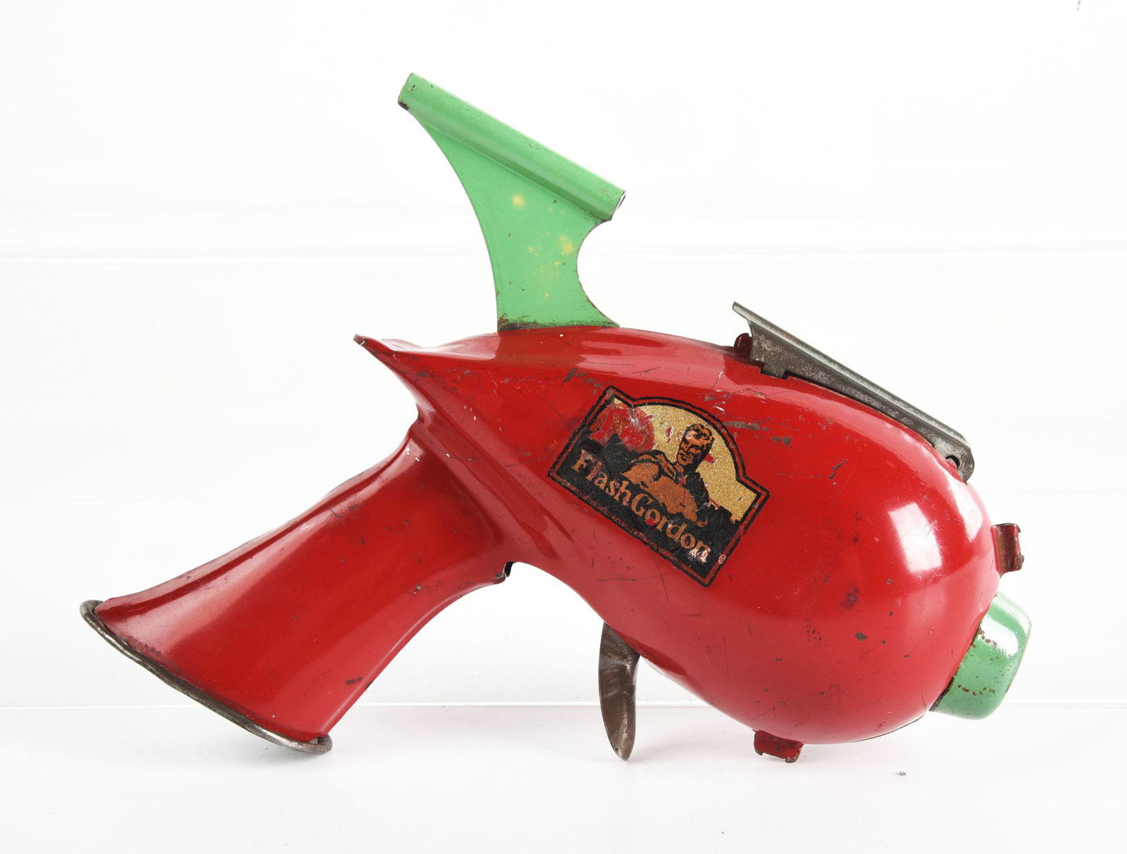 MARX TIN LITHO FLASH GORDON ROCKET PISTOL.: Nice decal of Flash Gordon on one side. Has siren sound and some mild to moderate paint chipping throughout. Condition: (Very Good). Dimensions: 7" x 7 - 1/4" x 2".