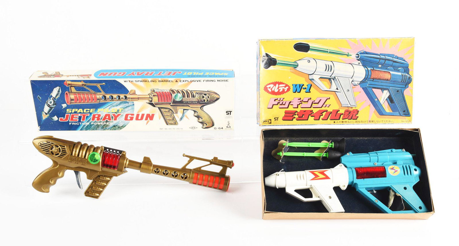 LOT OF 2: JAPANESE PLASTIC SPACE GUNS IN ORIGINAL BOXES.: Both friction. There is a space pilot jet ray gun and w-1 ray gun. Both boxes marked st. Condition: (Very Good - Excellent). Dimensions: Largest Box: 16 - 1/4" x 4 - 1/4" x 2" .