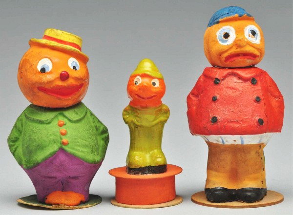 Lot of 3: Halloween Pieces.: Includes one Veggie Man on box candy container, one Veggie Child with red double breasted coat, pumpkin head, and blue cap, and one Veggie Man candy container with green coat, yellow hat, purple pants