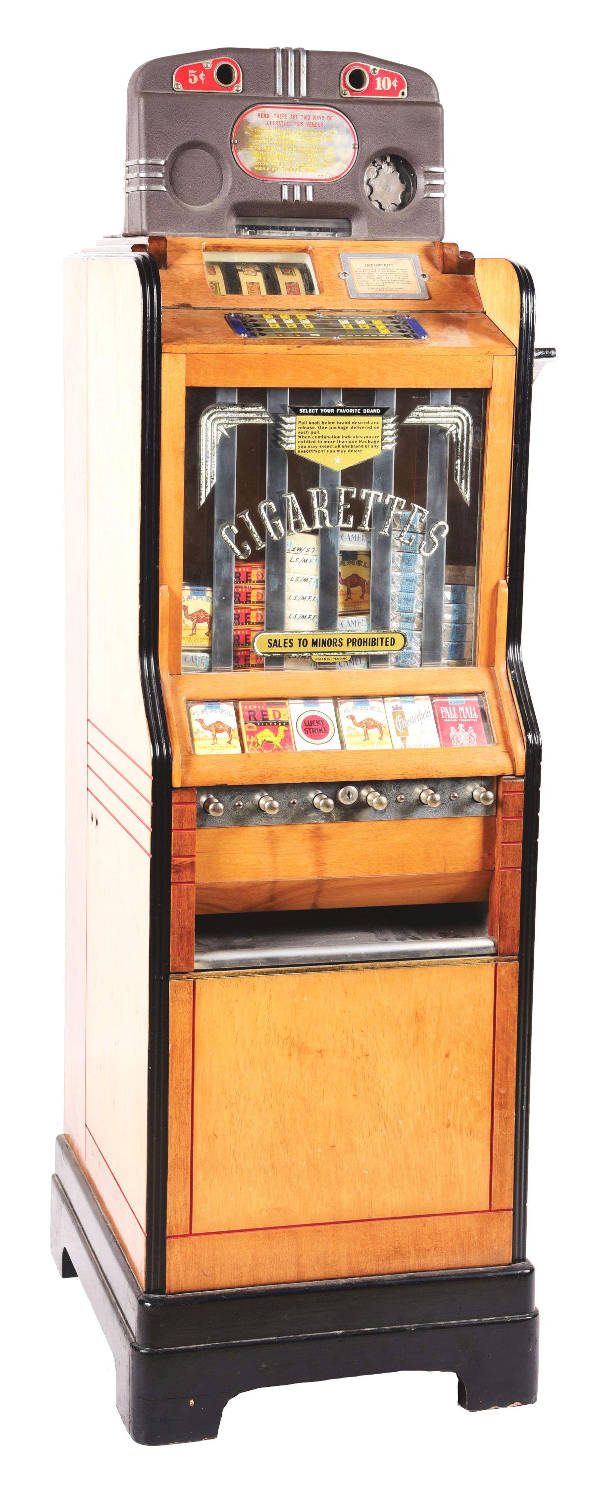 5 & 10¢ O.D. JENNINGS CIGA-ROLA FLOOR MODEL SLOT MACHINE.: This machine offers the operator the choice between purchasing a pack of cigarettes with or without a gambling element, serving as a cigarette vending machine and slot machine with cigarette awards. I