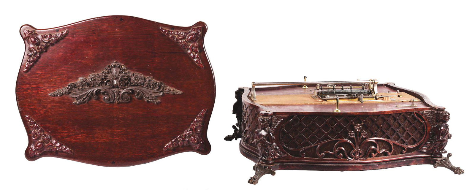 RARE REGINA PROTOTYPE REGINAPHONE WITH CARVED FIGURINE BASE.: Very little is know regarding this instrument. Believed to be a prototype, it has all the markings of a Reginaphoine in a heavily carved case, with cherubs and lattice and claw feet. Equipped to play