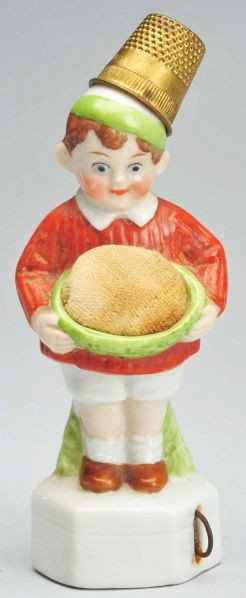 Boy Tape Measure, Pin Cushion, & Thimble Holder.: German. Porcelain. Metal thimble. Original full spring tape. Condition (Excellent). Size 4" T.