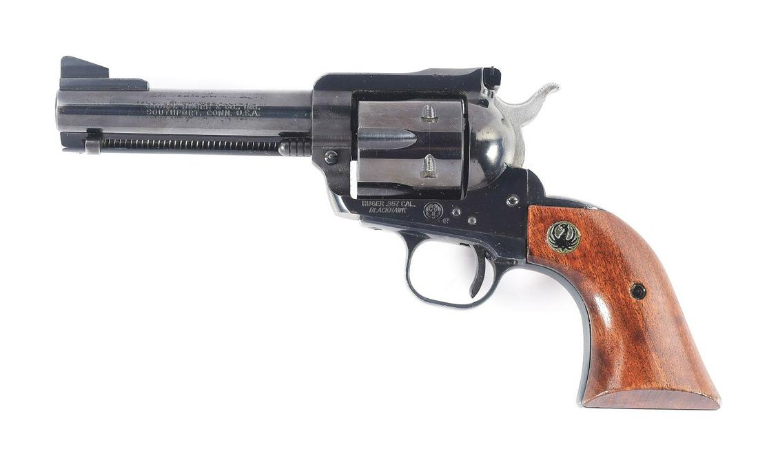 (C) RUGER BLACKHAWK SINGLE ACTION REVOLVER.: Round barrel with a ramp front sight and an adjustable rear sight. Flat top single action with a 6-shot fluted cylinder. 2-piece wood grips with the Ruger logo medallions at the top of each grip. Acti