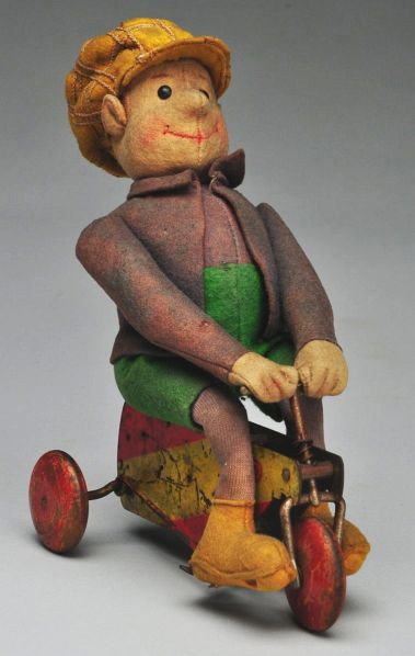 Rare Steiff Boy Riding Tricycle.: Description Early Steiff FF button in ear; all felt doll with character face, seam down center, black shoe button eyes, inset mohair wig just about gone but covered by hat, yellow and red metal key-wi