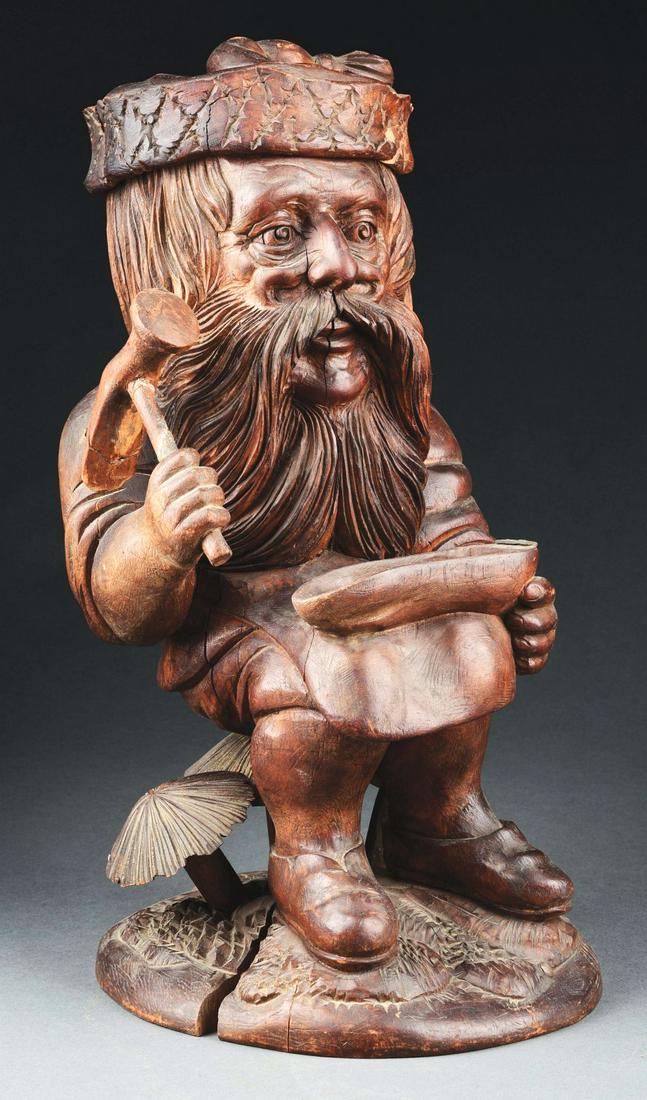 FIGURAL WOODEN OLD MAN TOBACCO HUMIDOR.: Great looking face and full-bodied mushrooms on base. Condition: Repair and moderate wood losses to cap. 3" split to base. Split through wrist and leg. Shoe-shaped receptacle with hinge is missing top