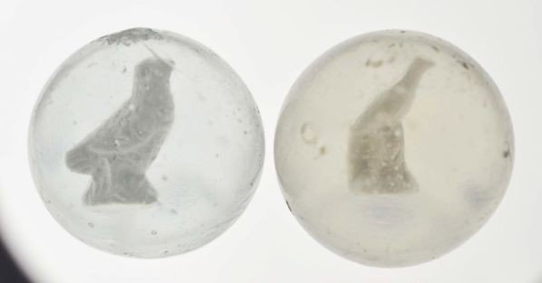 Lot of 2: Sulphide Marbles.: Description The smaller marble is a bird with long tail figure, photo list: B, C, and D. The larger marble is a European quail (short tailed bird?) figure, photo list: C and D. Condition (8.8). Size 1
