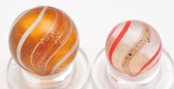 Lot of 2: Banded Lutz Marbles.: Description Smaller marble is a peewee clear base with red lines and lutz bands. Photo list: B, C, and D. The larger marble has an amber base with white lines and gold bands. Photo list: B, C, and D. 