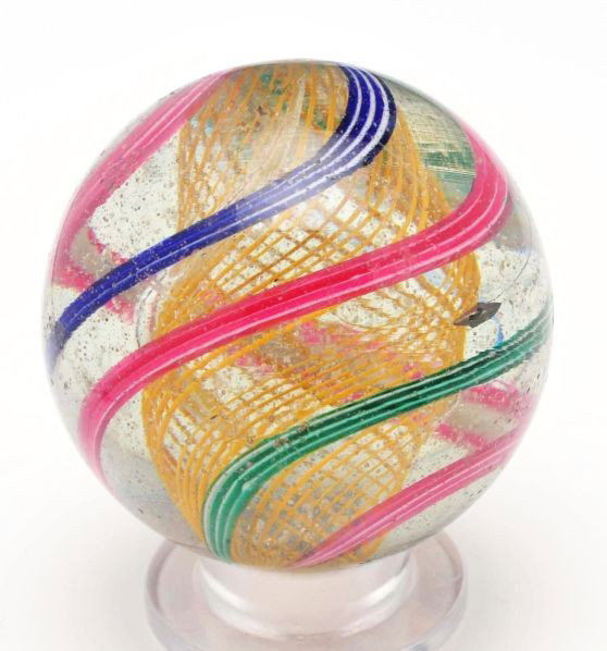 Large Yellow Latticino Swirl Marble.: Description Yellow latticino core with two red and white bands alternating with a blue and white band and a green and white band. One shallow chip and minor surface wear. Photo list: B, C, and D. Cond