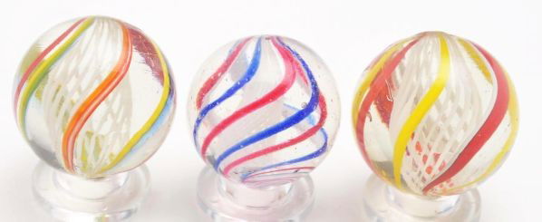 Lot of 3: White Latticino Swirl Marbles.: Description Includes two white latticinos with bright English colors and one tornado twist white latticino caged in alternating blue underlaid in white and red underlaid in white. Condition (9.6). Siz