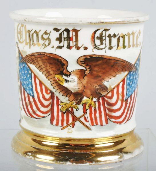 Patriotic Shaving Mug.: Description Gilt name "Chas. M. Crane". Shows crossed American Flags and a beautiful bald eagle with open wings. Blue wrap. Marked "T&V France" on bottom. One minor crack at top of the handle.Conditio