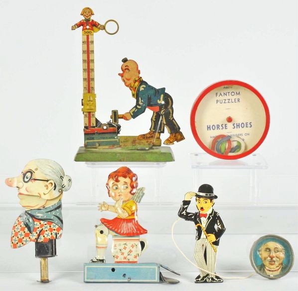 Lot of 6: Misc. Squeeze Toys & Dexterity Puzzles.: Description German. Includes one Charlie Chaplin hat tipper, one girl on potty, one grandma sparkler, one Gely clown hitting high-striker, and two dexterity puzzles.Condition (Very Good). Size Largest