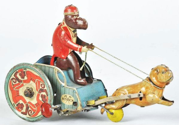 Tin Litho Strauss Jolly-Pals Wind-Up Toy.: Description American. Working. Marked "Stock" on both sides of toy. Depicts a monkey riding a cart pulled by a bulldog with lithographed monkeys on both rear wheels. Some scratching and wear overall.C