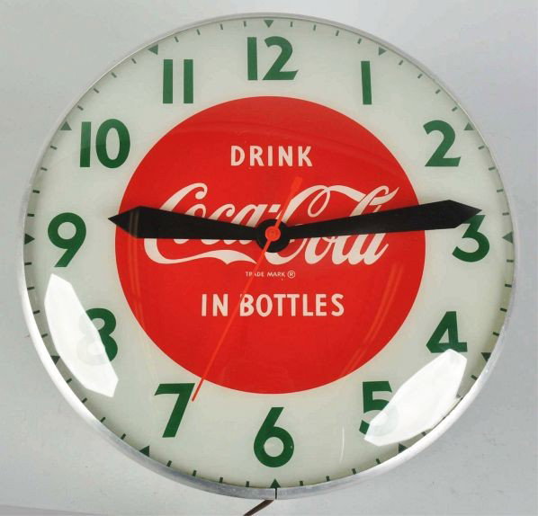 Coca-Cola Electric Light-Up Clock.: Description 1950s. Beautiful clock with almost no wear or soiling noted. A few miniscule outer case marks and surface scratches to outer glass.Condition (Near Mint). Size 15" Dia.