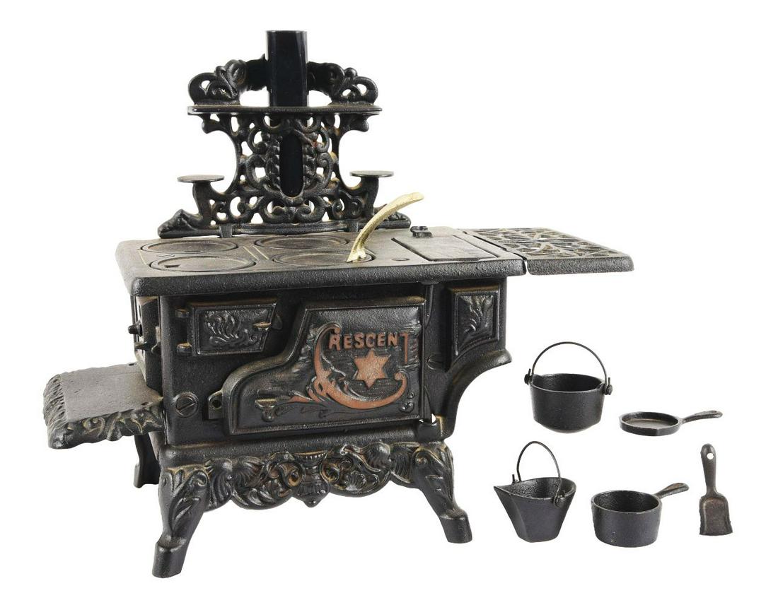 LATER CASTING CAST IRON CRESCENT STOVE.: Comes with pots and pans accessories, original tin stack. Very little wear.Condition:(Excellent).Dimensions:8 - 1/2" x 6" x 7".