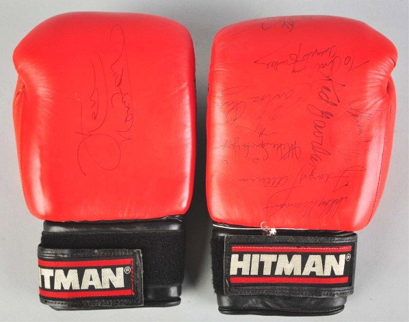 Pair of Hitman Autographed Boxing Gloves.: Description Includes signatures from several championship and HOF boxers such as Ken Norton, Floyd Patterson, Carlos Ortiz, Michael Spinks, and others. Some signatures have some smearing. Includes an 