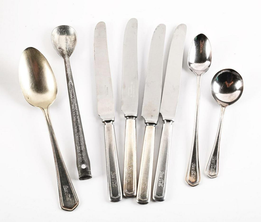 LOT OF COCA-COLA SILVERWARE.: Includes eight pieces of Coca-Cola silverware. Two butter knives are marked "The Straus Co. Richmond, VA. Stainless." Two butter knives are marked "Wallco All Stainless." One serving spoon is marked "
