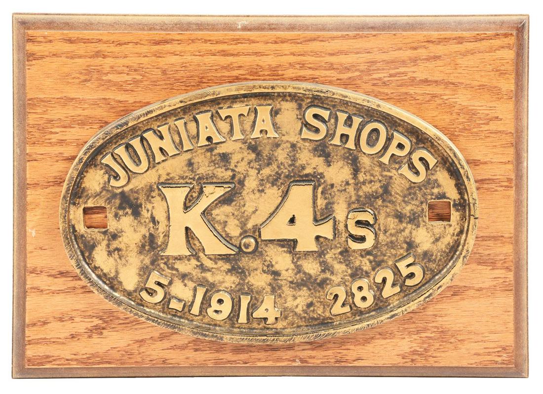 STEAM LOCOMOTIVE BUILDER'S PLATE REPRODUCTION.: A resin reproduction, oval-shaped Juniata K4s locomotive builder's plate. Mounted on an oak plaque board. Condition:(9).14" x 10" x 1 - 1/8".Dimensions:
