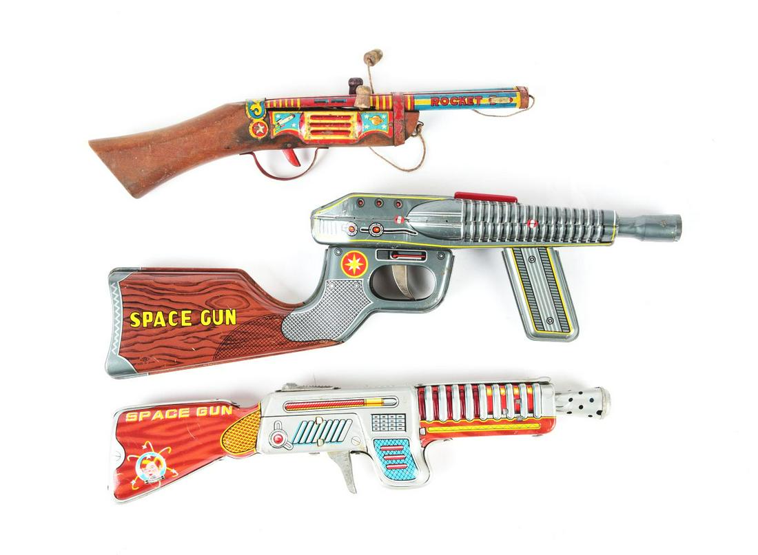 LOT OF 3: MADE IN JAPAN TIN LITHO FRICTION SPACE RIFLES.: Two are marked "Space Gun," and the other is marked "Rocket." The Rocket gun has a wooden stock. Condition:(Very Good - Excellent).Largest: 15 - 1/4" x 4" x 1 - 1/2".Dimensions: