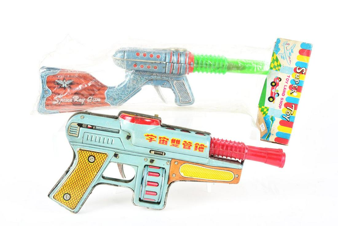 LOT OF 2: JAPANESE & CHINESE TIN LITHO DOUBLE BARREL SPACE GUNS.: One in original packaging marked "Space Ray Gun," made by Nomura. The other is marked "Made in China" and "Space Gun Double Barrel." Chinese gun has scratching and wear throughout. Condition:(Very Goo