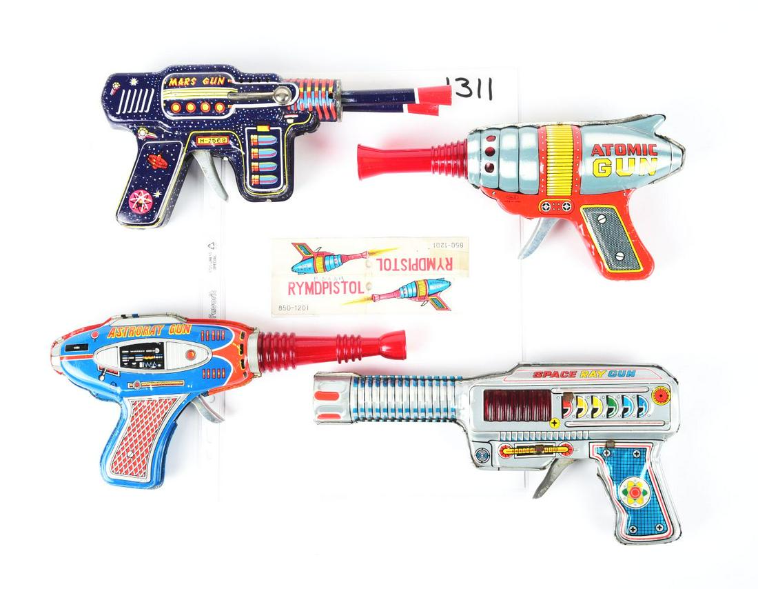 LOT OF 4: JAPANESE TIN LITHO 7 PLASTIC RAY GUNS.: Mars Gun, Atomic Gun with header card, Space Ray Gun and an Astroray Gun, which is not working. Some scratching.Condition:(Very Good).Largest: 9 - 3/4" x 4 -1/2" x 1 - 1/4".Dimensions: