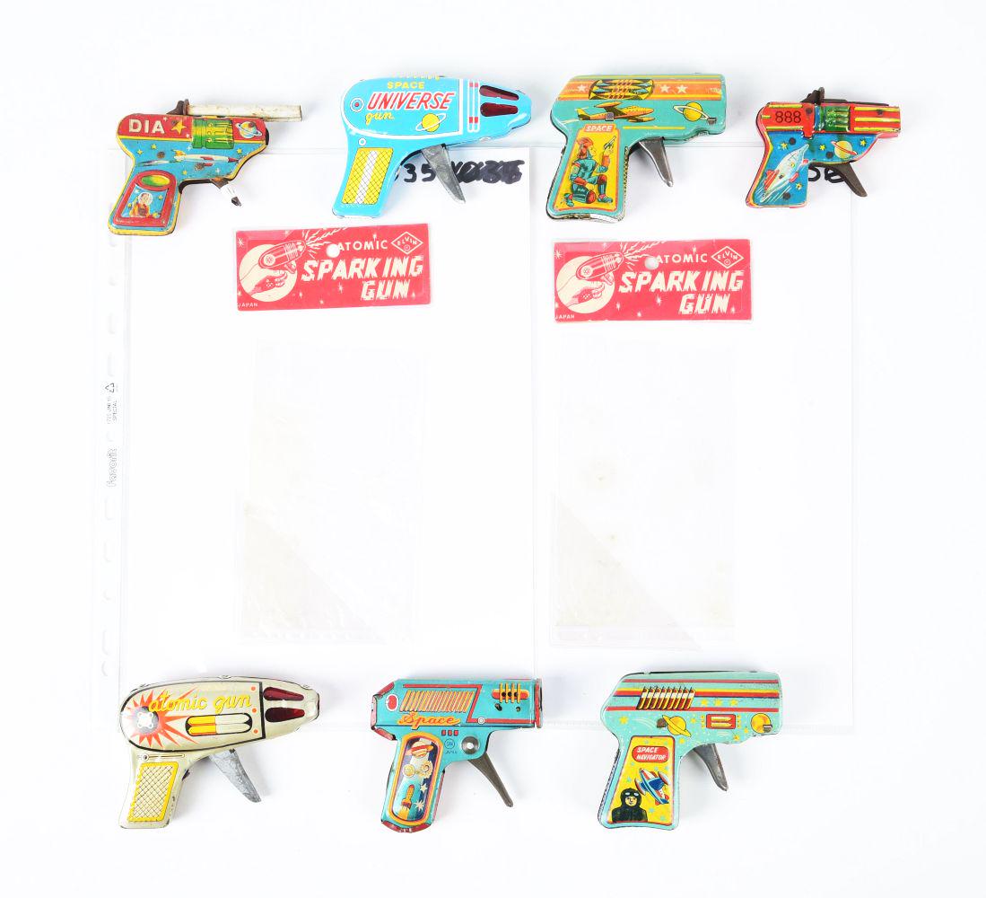 LOT OF 7: JAPANESE TIN LITHO SPACE GUNS.: Smaller versions and two with sparking original header cards. Space Universe Gun and others. Some wear and scratching.Condition:(Very Good).Largest: 4" x 3" x 1/2".Dimensions: