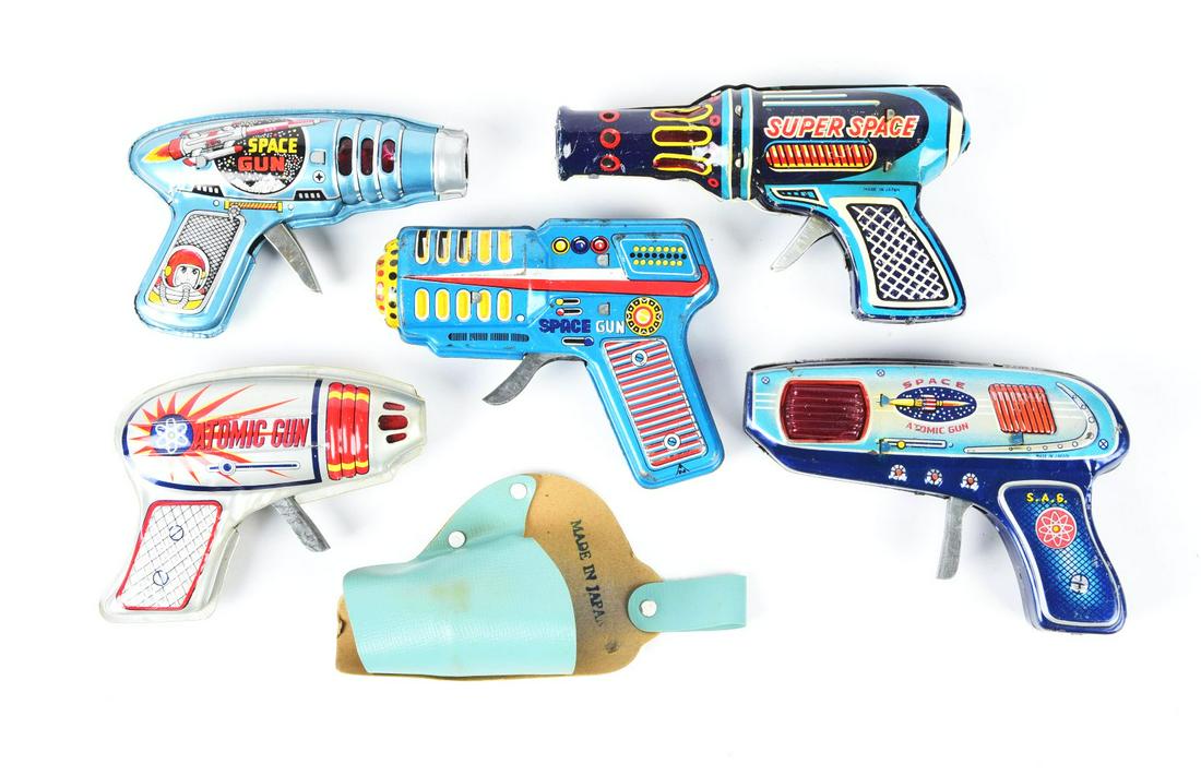 LOT OF 5: TIN LITHO JAPANESE SPACE GUNS.: One marked "Atomic Gun," two marked "Space Guns" and others. Some scratching and wear. One has a holster.Condition:(Very Good).Largest: 6 - 1/2" x 4" x 1".Dimensions: