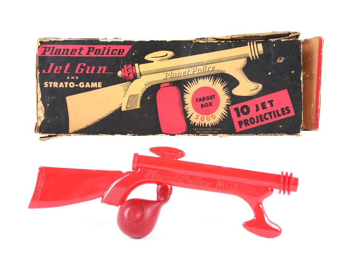 AMERICAN-MADE PLASTIC PLANET POLICE JET GUN & BOX.: Box has some tearing and creasing. Gun is marked "Planet Police M.P.G 1." Unusual firing mechanism, with air bag squeeze eject projectiles. There are 6 original projectiles.Condition:(Very Good).11 - 